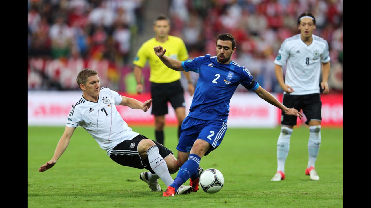 Germany's Bastian Schweinsteiger, left, tackles Giannis Maniatis of Greece.