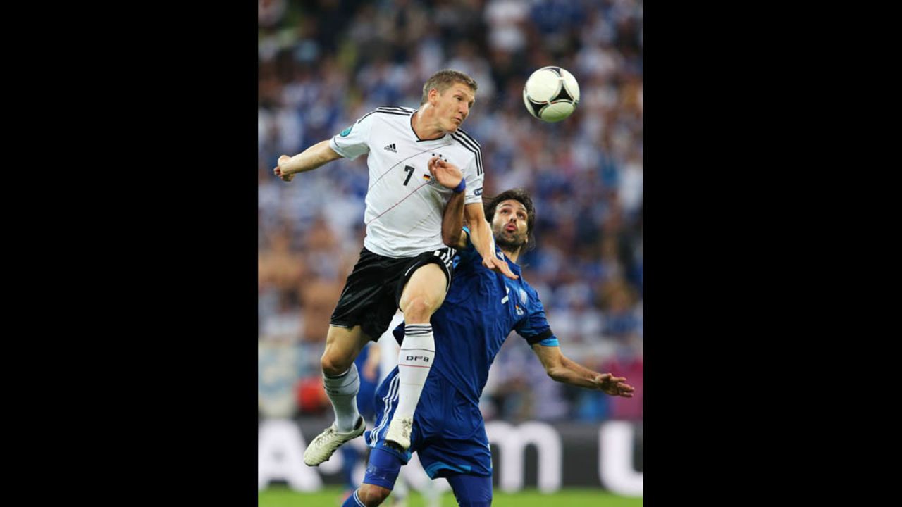Germany's Bastian Schweinsteiger beats Greece's Georgios Samaras to the ball.