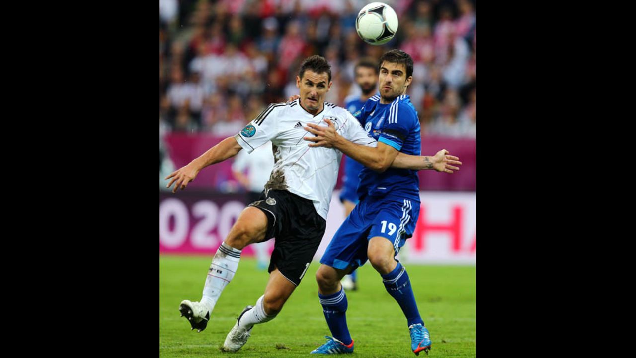 Miroslav Klose of Germany and Sokratis Papastathopoulos of Greece fight for the ball.