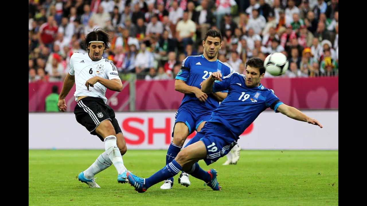 Greece's Sokratis Papastathopoulos and Germany's Sami Khedira compete for the ball.