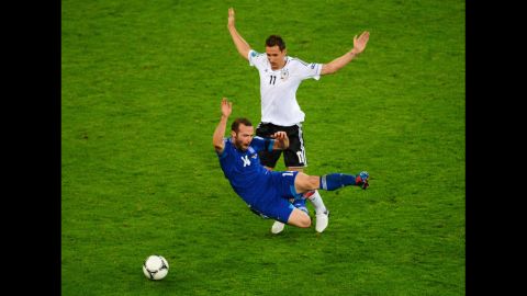 Germany's Miroslav Klose clashes with Greece's Dimitris Salpigidis.