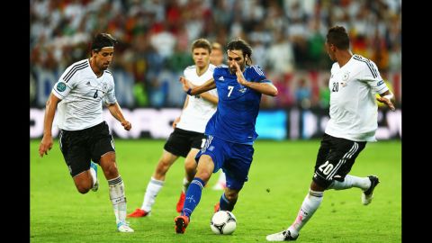 Georgios Samaras of Greece dribbles by Sami Khedira, left, and Jerome Boateng of Germany during the quarterfinal match between Germany and Greece.