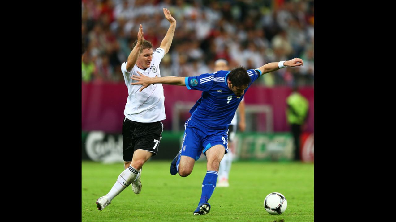 Bastian Schweinsteiger of Germany tackles Nikos Liberopoulos of Greece during the quarterfinal match between Germany and Greece.
