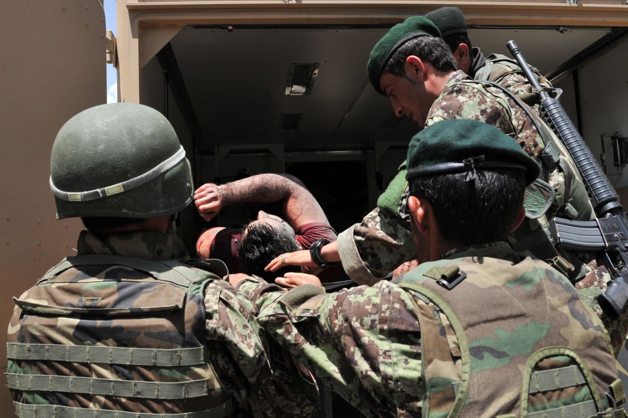 Afghan soldiers remove the body of a civilian after the standoff ended. Militants killed 15 civilians, a police officer and three security guards, according to authorities. 