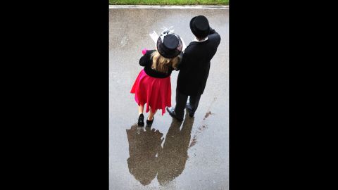 A couple stand in a puddle at Royal Ascot.