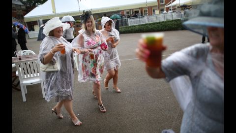 Race-goers wear plastic rain covers over their dresses during some showers.