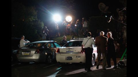 Sandusky is escorted in handuffs to a police car at the Centre County Courthouse under the glare of TV lights. The jury found Sandusky guilty on 45 of 48 counts.