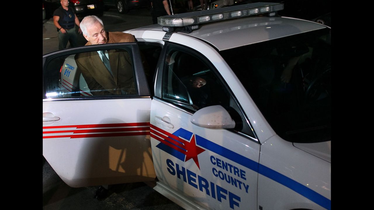 Sandusky is put into a police car.