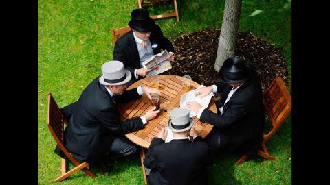 Racegoers sit at a table and study the form on Friday.