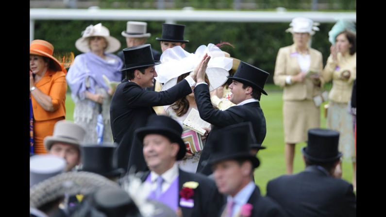 Two onlookers congratulate each other with a high-five.