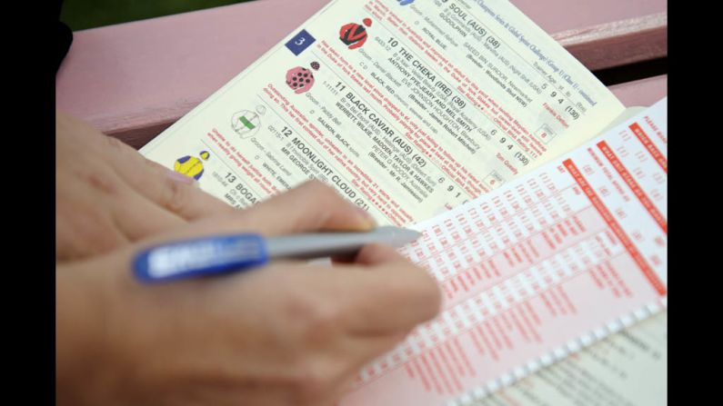 An attendee examines a booklet with descriptions of the racers.