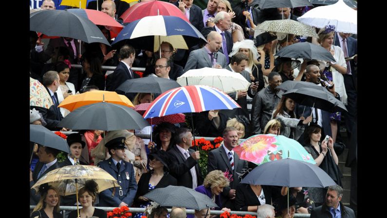 Attendees escape the rain under their umbrellas on day four.