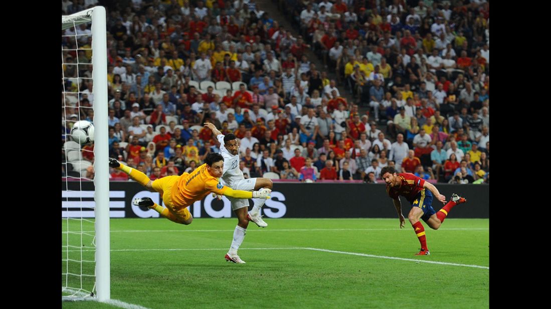 Xabi Alonso of Spain scores the first goal past Hugo Lloris of France.