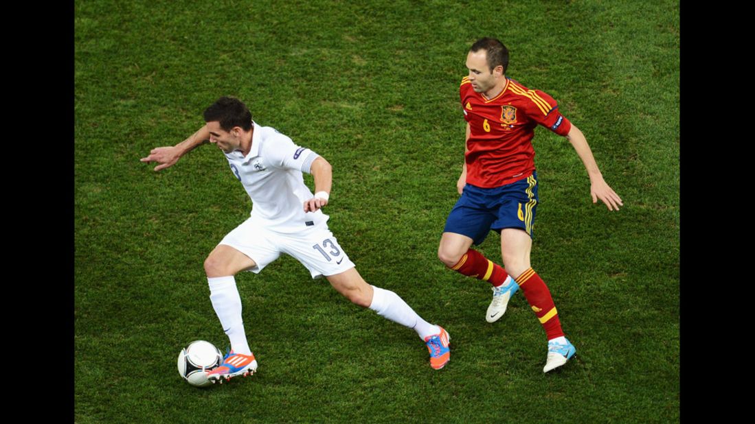 Anthony Reveillere of France is closed down by Andres Iniesta of Spain.