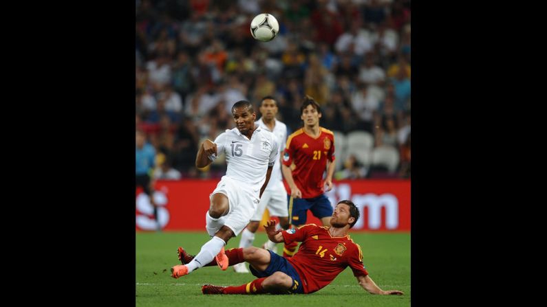 Xabi Alonso of Spain challenges Florent Malouda of France during the quarter final match between Spain and France.