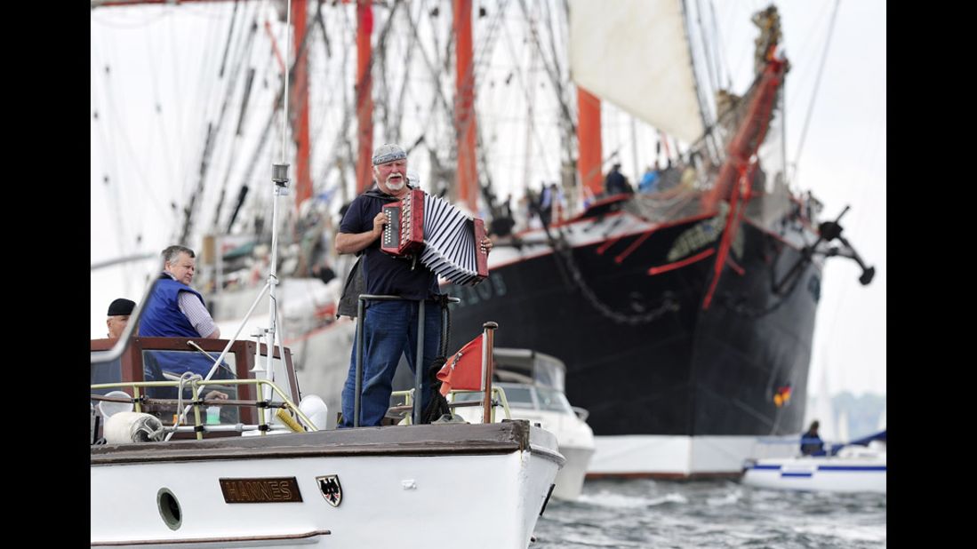  A man plays his accordion in front of the Russian tall ship Sedov at the Windjammer Parade.