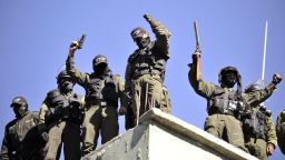 Armed mutinied policemen stand on the roof of a police headquarters in La Paz, on June 23, 2012 during a police strike demanding a salary increase.