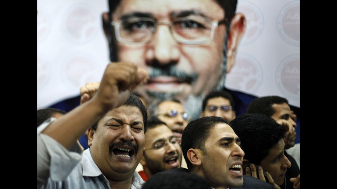 Morsi suppporters celebrate in front of a picture of him at his campaign headquarters in Cairo on June 24.