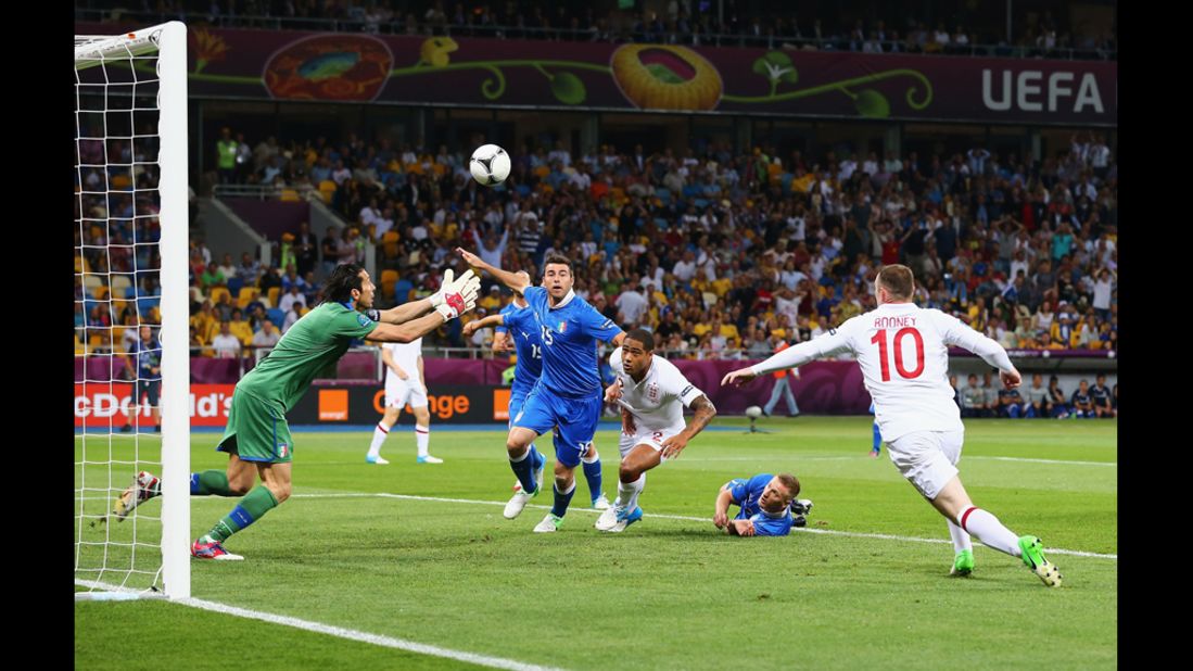 Gianluigi Buffon of Italy makes a save as Wayne Rooney of England runs in during the quarterfinal match.