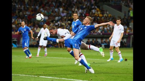 Wayne Rooney of England heads the ball as Ignazio Abate of Italy challenges during the quarterfinal match.