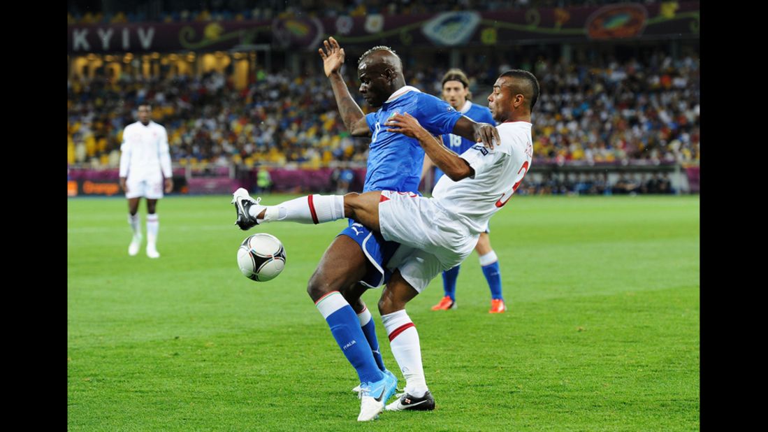 Mario Balotelli of Italy and Ashley Cole of England compete for control of the ball.