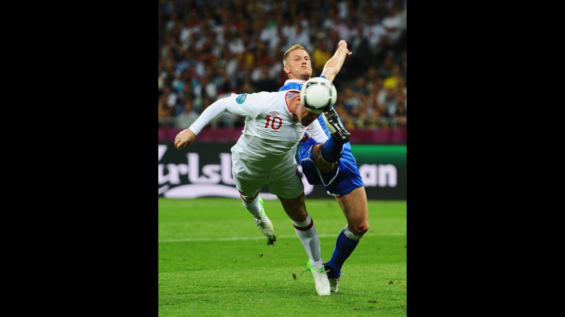 Wayne Rooney of England and Ignazio Abate of Italy go after the ball.