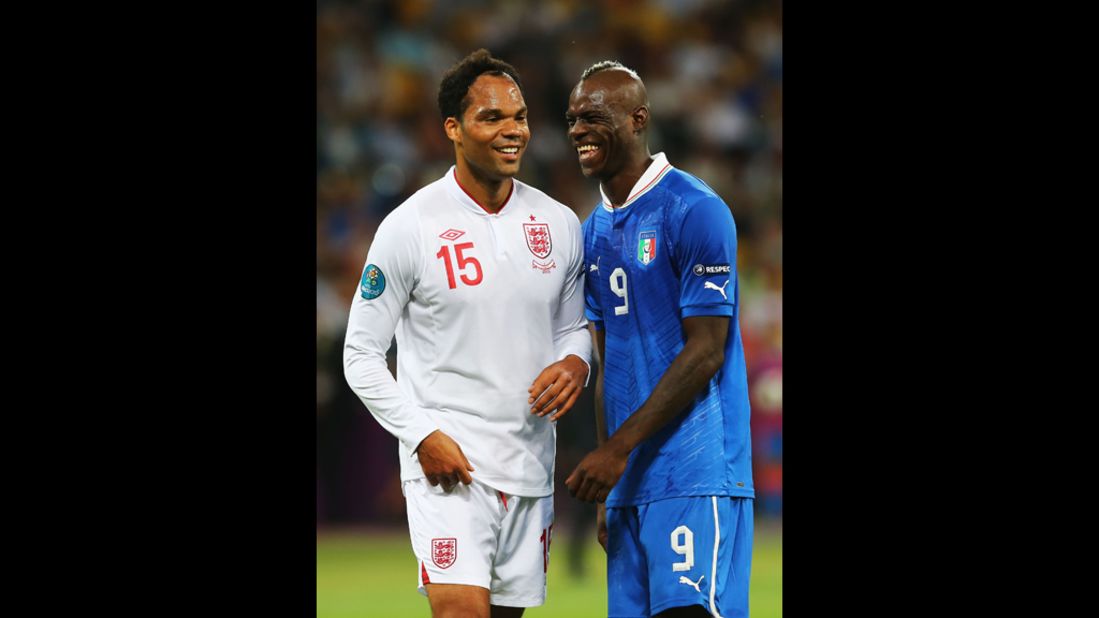 Joleon Lescott of England and Mario Balotelli of Italy share a moment during a break in the match.