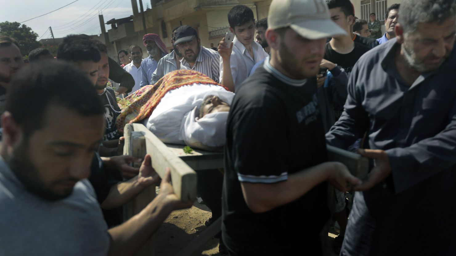 Syrian mourners carry the body of a victim of the previous day's shelling on the rebel stronghold of Qusayr on Saturday.