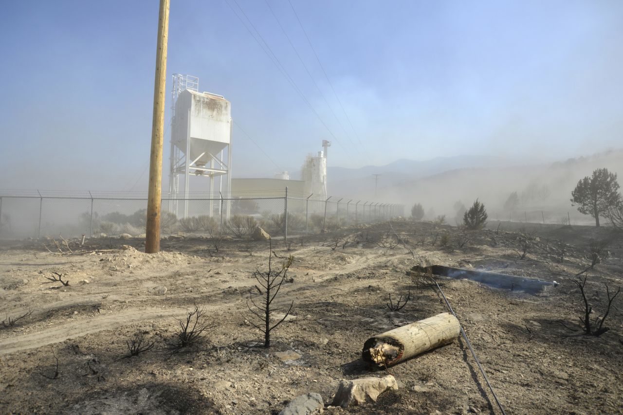 Smoldering earth and damage from the Dump Fire, which began June 21, can be seen outside a plant near Saratoga Springs, Utah, on Saturday, June 23.