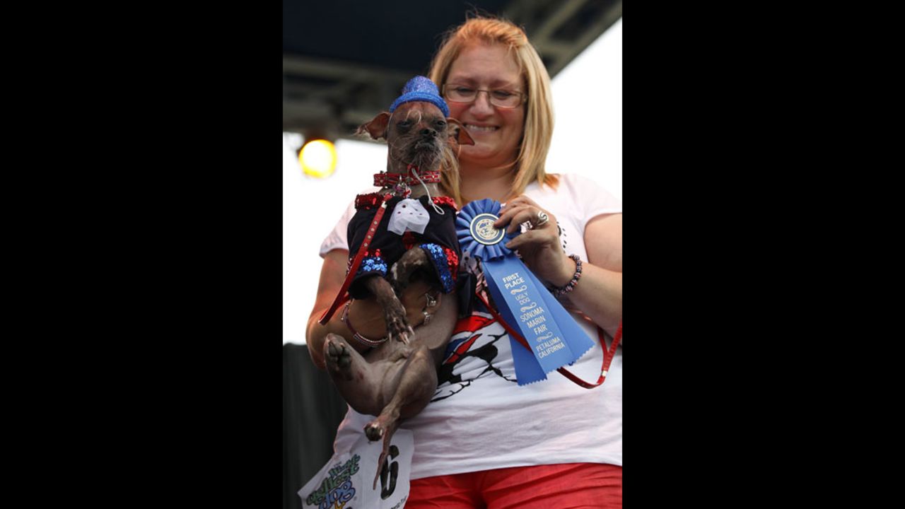 Bev Nicholson puts a ribbon on Mugly, who won $1,000 in prize money.