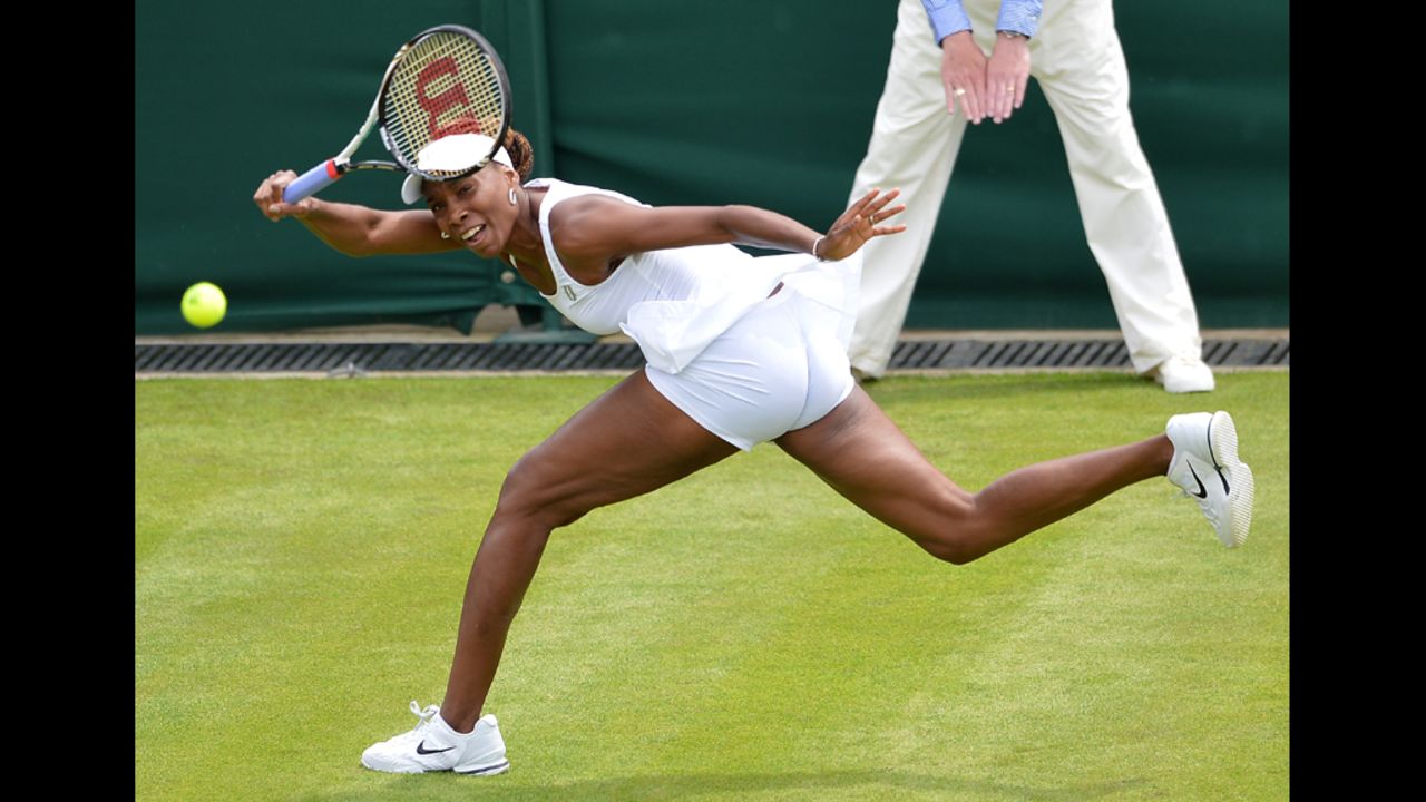 Venus Williams plays a shot during her first round women's singles match against Russia's Elena Vesnina on Monday, June 25, during the first round at Wimbledon. Williams lost the match, her earliest exit from the tournament in 15 years. 