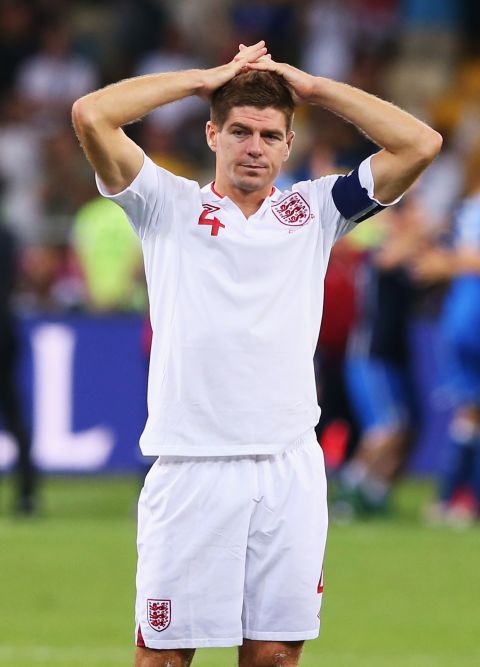 Captain Steven Gerrard stands dejected following England's exit from Euro 2012 on penalties after clinging on for most of their quarterfinal match with Italy. The team's performance drew much criticism, as they surrendered possession and territory in a defensive display, and prompted a debate about a change of direction for the national team.