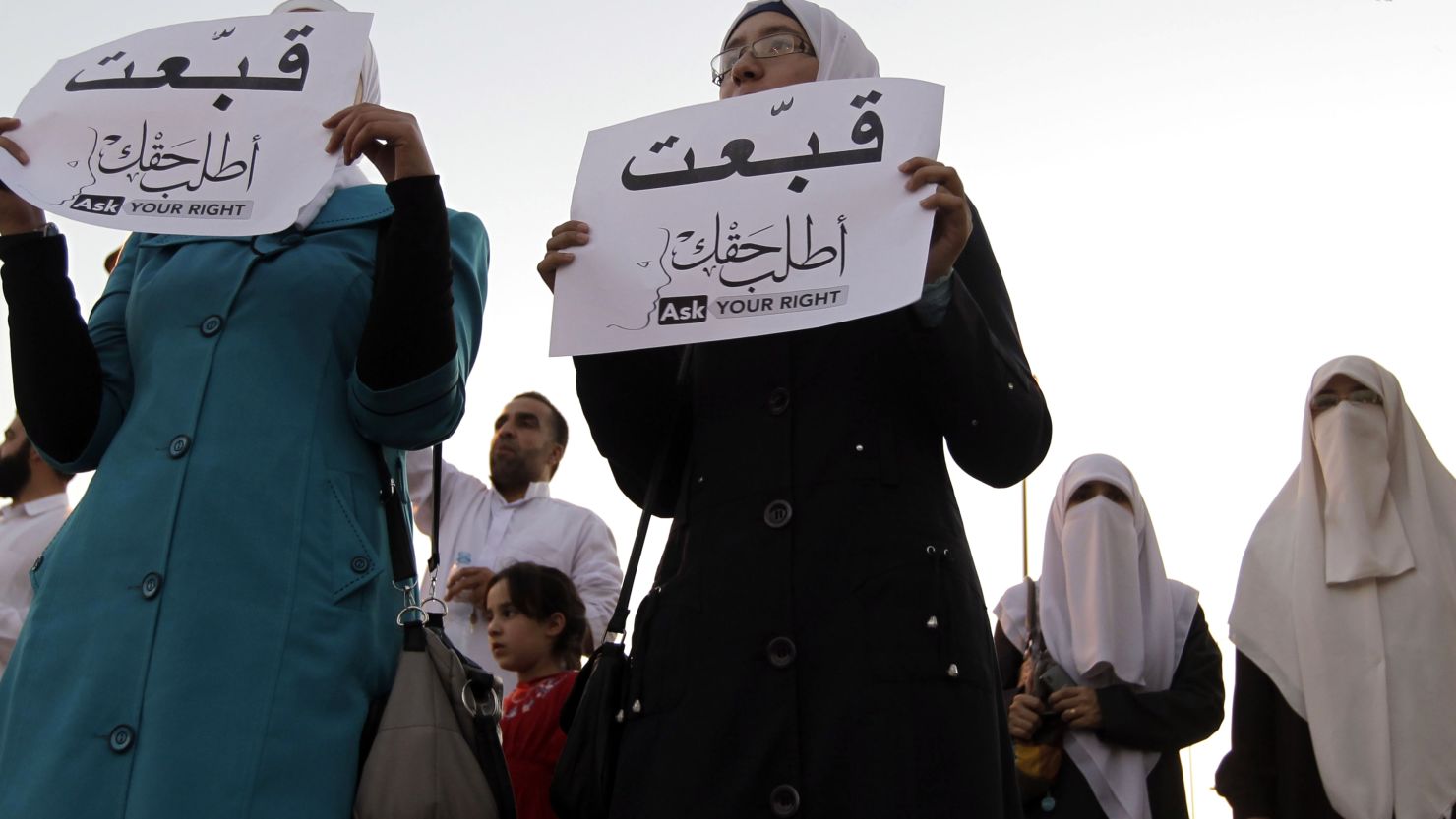Jordanian women hold up signs that say "ask for your rights."