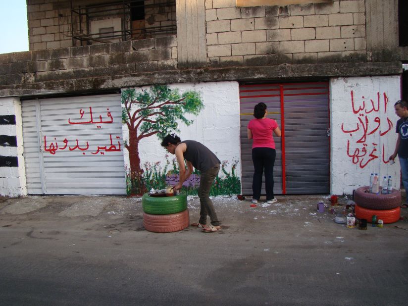 Layla Serhan and another YNCA member paint a mural in Nabatieh. The group aims to empower the town's young people, traumatized by the 2006 conflict with Israel, to voice their opinion; it spreads its message through art.