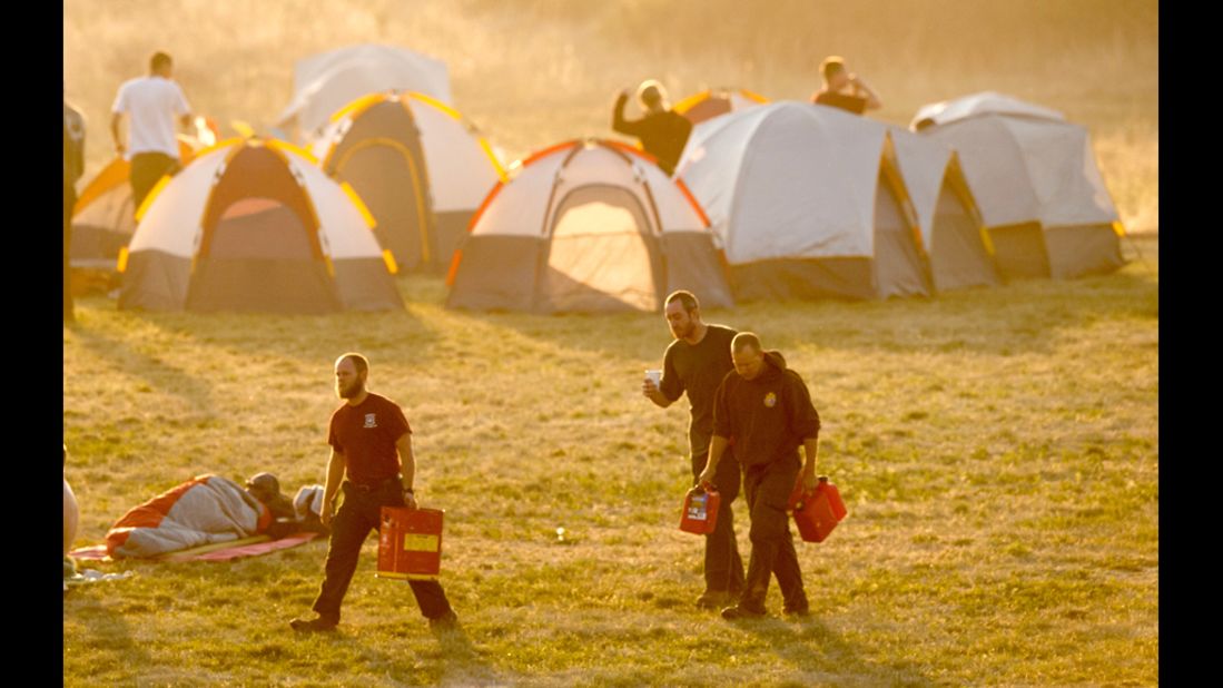 At dawn on Tuesday, firefighters stir from their tents at a camp near Holmes Middle School.