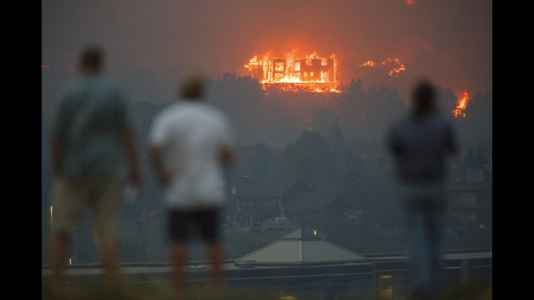 Residents of Colorado Springs watch as the Waldo Canyon Fire burns a home in the Mountain Shadows neighborhood on Tuesday.