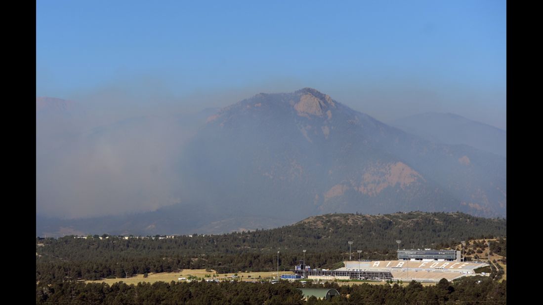 Hazy smoke from the Waldo Canyon Fire looms behind the Air Force Academy stadium on Wednesday, June 27, in Colorado Springs, Colorado. The fire expanded to 15,000 acres. More than 32,000 people have been evacuated.