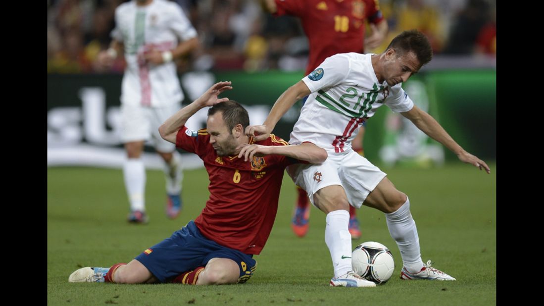 Spanish midfielder Andres Iniesta, left, falls while vying with Portuguese defender Joao Pereira.