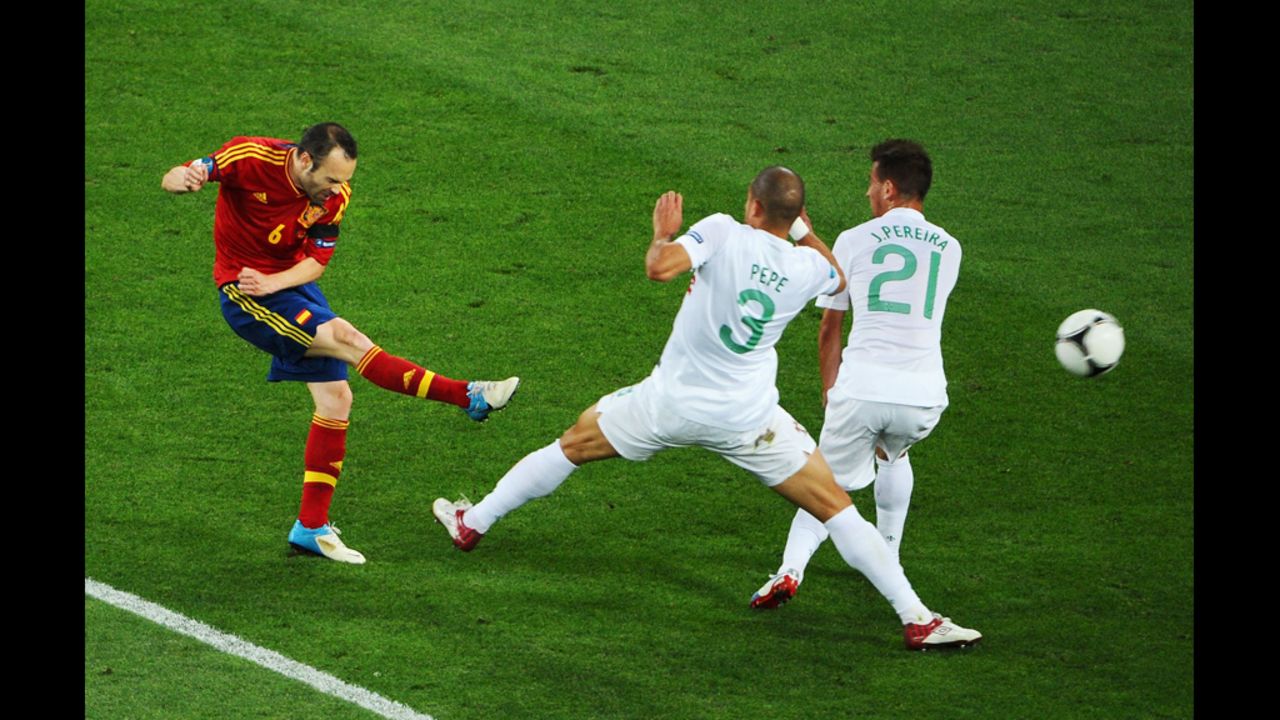 Andres Iniesta of Spain shoots past Pepe and Joao Pereira of Portugal.