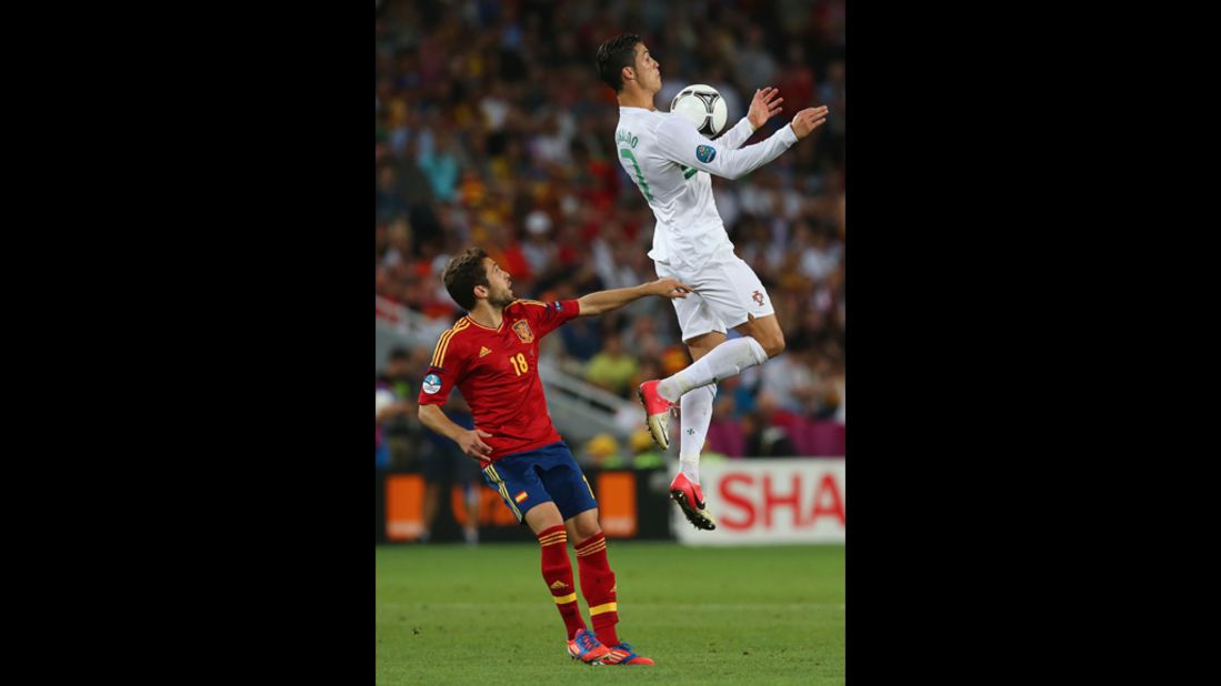 Cristiano Ronaldo of Portugal jumps for a high ball in front of Jordi Alba of Spain.