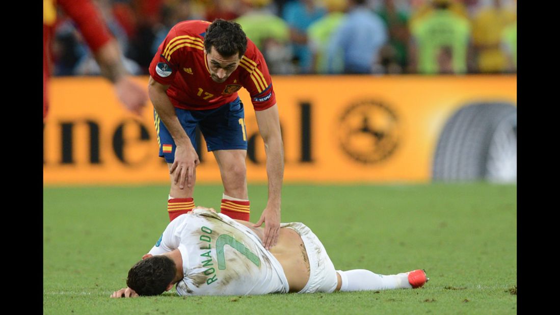 Portuguese forward Cristiano Ronaldo lies on the ground as Spanish defender Alvaro Arbeloa tries to help.