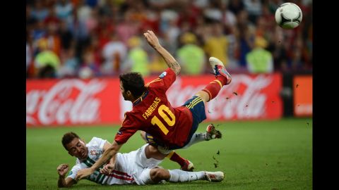 Spanish midfielder Cesc Fabregas is tackled by Portuguese defender Joao Pereira.