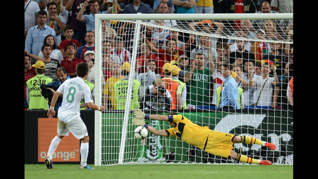 Spanish goalkeeper Iker Casillas stops a penalty kicked by Portuguese midfielder Joao Moutinho.