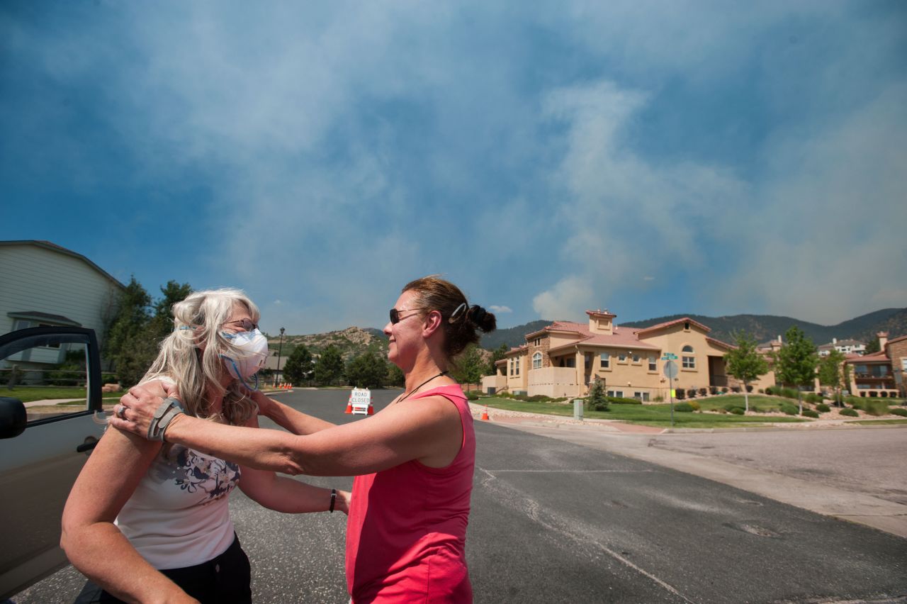 Jan Stone, right, comforts Angela Morgan as smoke from the Waldo Canyon Fire pours over the Mountain Shadows neighborhood of Colorado Springs on Tuesday.