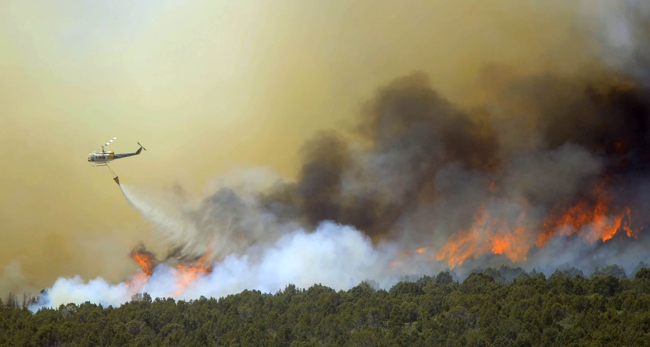 A helicopter drops water over the Wood Hollow Fire north of Fairview, Utah, on Tuesday, June 26