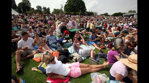Fans watch the men's singles second-round match between Andy Murray of Great Britain and Ivo Karlovic of Croatia on a large projection screen from the lawn June 28.