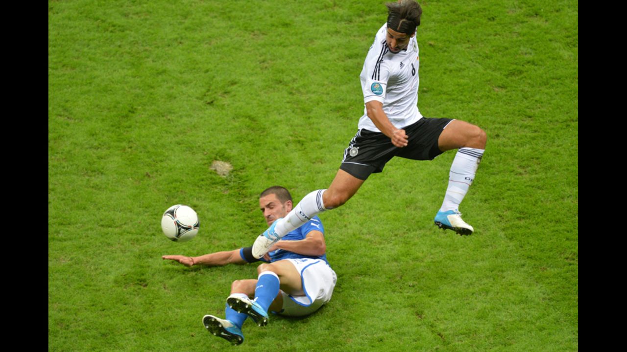 Italian defender Giorgio Chiellini slides under German midfielder Sami Khedira.