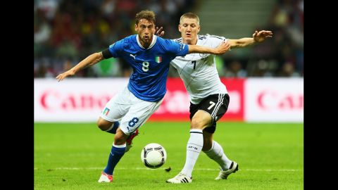 Claudio Marchisio of Italy and Bastian Schweinsteiger of Germany battle for the ball.