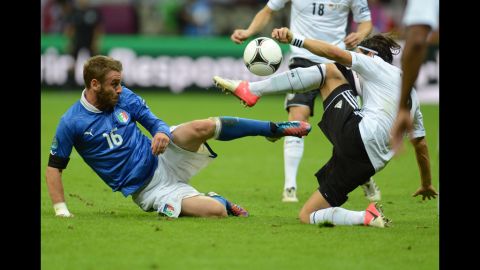 Italian midfielder Daniele De Rossi and German midfielder Mesut Ozil try to get control of the ball.