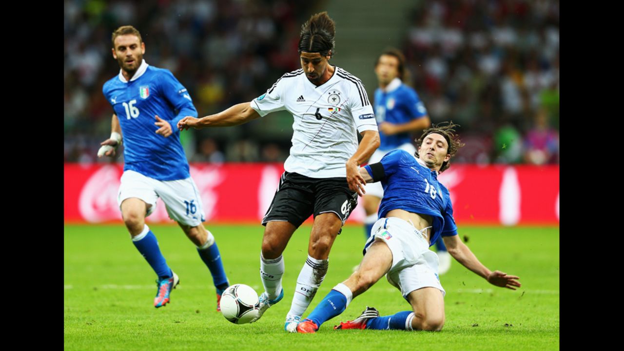 Sami Khedira of Germany, in white, battles for the ball with Riccardo Montolivo of Italy. 
